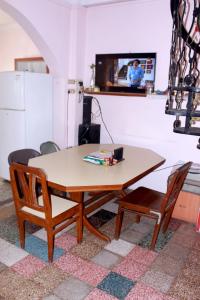 a kitchen with a table and chairs and a television at Perfect Homestay Ujjain in Ujjain