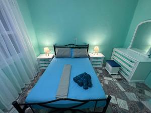 ein Schlafzimmer mit einem blauen Bett und zwei Nachttischen in der Unterkunft Mykonos Seaside Villa in Paralía Avdhíron