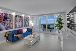 a living room with a blue couch and a table at Cloud Nine! Direct Water Views of Bay & Ocean! in Miami