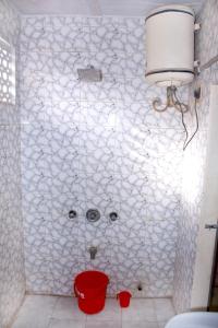 a bathroom with a white tiled wall with a face on it at Perfect Homestay Ujjain in Ujjain