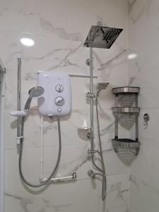 a shower with a shower head in a bathroom at Pool House Retreat in Accra in Accra