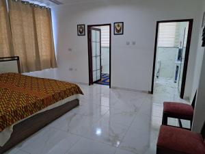 a bedroom with a bed and a door to a bathroom at Pool House Retreat in Accra in Accra +29 photos