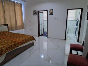 a bedroom with a bed and a door to a bathroom at Pool House Retreat in Accra in Accra