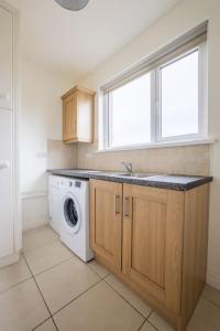 a kitchen with a washing machine and a window at Farnetra Lodge in Clogher