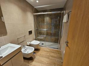 ein Bad mit einer Dusche, einem Waschbecken und einem WC in der Unterkunft Quinta de Casal do Bairro Casa do Alpendre in Guimarães