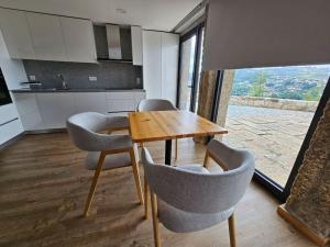 eine Küche mit einem Holztisch und Stühlen im Zimmer in der Unterkunft Quinta de Casal do Bairro Casa do Alpendre in Guimarães