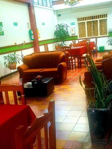 um restaurante com um sofá, mesas e cadeiras em Ayenda Hotel Piedecuesta em Piedecuesta