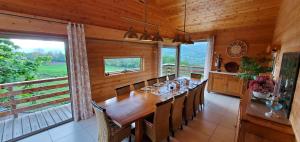 een eetkamer met een lange houten tafel en stoelen bij "La Coustille" Chambres et Table d'Hôtes in Saint-Léger-les-Mélèzes