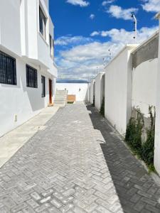 a cobblestone alleyway between two white buildings at Suite Los Sauces in Ibarra