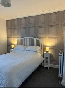 1 dormitorio con 1 cama blanca y 2 mesitas de noche en Camisila, en Campbeltown