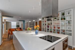 a kitchen with a white counter and a dining room at MK CITY CENTRE, THE DIAMOND SUITE, FREE Parking Space, PREMIUM SPACIOUS Apartment with FOOSBALL TABLE in Milton Keynes