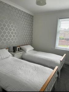 een slaapkamer met 2 aparte bedden en een raam bij Camisila in Campbeltown