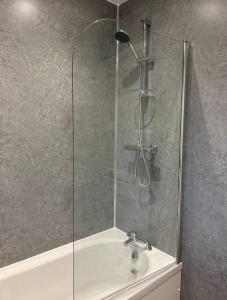 a shower with a glass door next to a sink at Camisila in Campbeltown