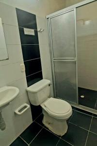 uma casa de banho com um WC e uma cabina de duche em vidro. em Ayenda Hotel Piedecuesta em Piedecuesta