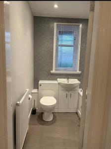 een badkamer met een toilet, een wastafel en een raam bij Camisila in Campbeltown