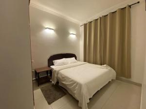 Homely 2-Bedroom at Victoria Place في دار السلام: غرفة نوم بسرير ابيض ومرآة