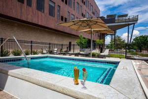 two glasses of beer sitting next to a swimming pool at Hotel Maverick in Grand Junction