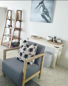 a living room with a chair and a desk at Adrift Guesthouse St Francis Bay in St Francis Bay