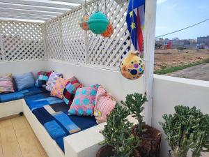 einen Balkon mit einem Sofa und Kissen auf einer Veranda in der Unterkunft Casa Djarmai Boutique Apartments in Vila do Maio