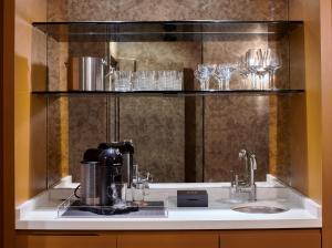 ロサンゼルスにあるHotel Ziggy On Sunsetの棚にコーヒーメーカーとグラスが置かれたカウンター