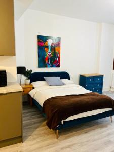 a bedroom with a bed and a painting on the wall at Beautiful Central Woking Studio in Woking