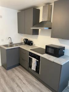 a kitchen with a microwave oven and a sink at Beautiful Central Woking Studio in Woking