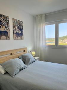 1 dormitorio con cama y ventana en Porta de Laxe, vistas al mar., en Laxe