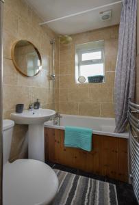 a bathroom with a sink and a tub and a mirror at Vicarage House in Blackpool