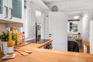 una cucina con pareti bianche e ripiano in legno di Familievennlig hytte ved populært badevann! a Sandefjord