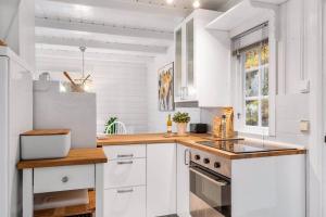 une cuisine avec des placards blancs et un comptoir en bois dans l'établissement Familievennlig hytte ved populært badevann!, à Sandefjord