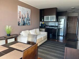 sala de estar con sofá y cocina en Reñaca Departamento Holiday Park 605 cómodo y buena ubicación familiar, en Viña del Mar