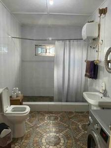 a bathroom with a toilet and a sink and a shower at Anne’s Beach House in Nyanyanu