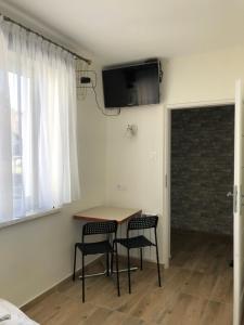 a room with a table and two chairs and a television at Noclegi Bachowice - Zator Energylandia Wadowice in Bachowice