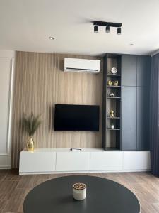 uma sala de estar com televisão na parede em NOMAD Apartments em Niš