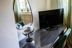 a mirror on a table with a television and chairs at Woodborough Hall in Woodborough