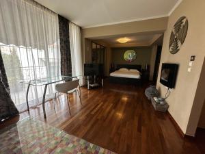 una camera d'albergo con letto e tavolo in vetro di Andromeda Suites ad Atene