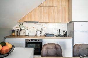 uma cozinha com armários de madeira e uma bancada em NOMAD Apartments em Niš
