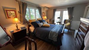 una camera da letto con un letto con lenzuola e cuscini blu di Gîte du Caméléon a Sherbrooke