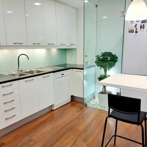a kitchen with white cabinets and a sink and a table at Casa da Praça in Miranda do Douro