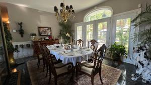 a dining room with a table and chairs and a chandelier at Gîte du Caméléon in Sherbrooke