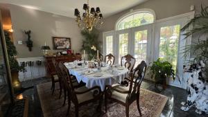 une salle à manger avec une table, des chaises et un lustre dans l'établissement Gîte du Caméléon, à Sherbrooke