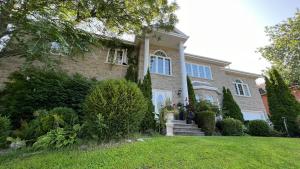 una grande casa in mattoni con un prato di Gîte du Caméléon a Sherbrooke