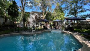 a swimming pool in a yard with umbrellas at Gîte du Caméléon in Sherbrooke