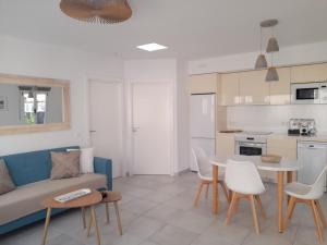a living room with a couch and a table and chairs at Bungalow Paseo del Mar- PLAYA ROCA Residence sea front access - Free AC - Wifi in Costa Teguise +32 photos