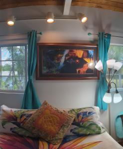a bedroom with a bed and a painting on the wall at Hilo Luxury Suite in Hilo