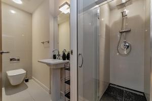 a bathroom with a shower and a sink and a toilet at MK CITY CENTRE, THE DIAMOND SUITE, FREE Parking Space, PREMIUM SPACIOUS Apartment with FOOSBALL TABLE in Milton Keynes +49 photos