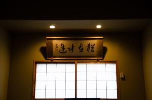 a sign on a wall above a window at Wafu Ryokan Uehonmachi in Osaka