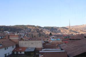 a view of a city with buildings and a church at Pachamama Hostel in Cusco