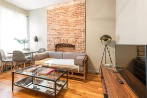 a living room with a couch and a brick wall at Amazing 1Br in Manhattan in New York