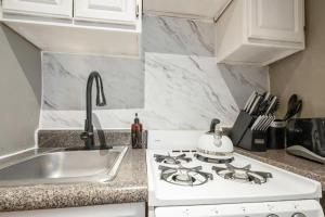 uma cozinha branca com um fogão e um lavatório em Amazing 1Br in Manhattan em Nova York